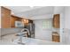 Kitchen with wooden cabinets and stainless steel fridge; sink overlooks the living area at 2650 Countryside Blvd # A104, Clearwater, FL 33761