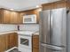Cozy kitchen featuring stainless steel fridge, white appliances, and wooden cabinets at 2650 Countryside Blvd # A104, Clearwater, FL 33761