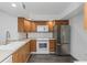 Kitchen with stainless steel refrigerator, wood cabinets and white appliances at 2650 Countryside Blvd # A104, Clearwater, FL 33761
