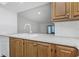 Kitchen with white counter, wooden cabinets and sink that overlooks the living area at 2650 Countryside Blvd # A104, Clearwater, FL 33761