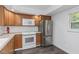 Kitchen with stainless steel refrigerator, wood cabinets, and vinyl flooring at 2650 Countryside Blvd # A104, Clearwater, FL 33761
