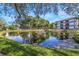 Scenic view of pond with fountain surrounded by lush greenery and complex building in the background at 2650 Countryside Blvd # A104, Clearwater, FL 33761