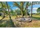 Picturesque backyard featuring a fire pit, Adirondack chairs, and lush greenery, ideal for relaxation at 27477 Old Trilby Rd, Brooksville, FL 34602