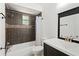 Cozy bathroom features tiled shower and bathtub combination, new sink and dark wood cabinets at 27477 Old Trilby Rd, Brooksville, FL 34602