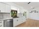 The white kitchen features stainless steel appliances, dark fixtures, and backyard views at 27477 Old Trilby Rd, Brooksville, FL 34602