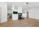 Bright living room features a modern fireplace, wood floors, and adjacent updated kitchen at 27477 Old Trilby Rd, Brooksville, FL 34602