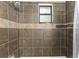 Beautiful tiled shower and bathtub combination includes inset window at 27477 Old Trilby Rd, Brooksville, FL 34602