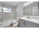 Updated bathroom featuring a tiled shower, new vanity with grey cabinets, and a modern mirror and lighting fixture at 2873 Karen Ave, Largo, FL 33774