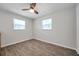 Bright bedroom with wood-look tile floors, ceiling fan, and two windows at 2873 Karen Ave, Largo, FL 33774