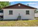 Rear exterior of home with white walls, brown trim, windows, and green grass in the backyard at 2873 Karen Ave, Largo, FL 33774