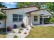 Charming home features a well-manicured lawn, complemented by decorative rock accents and lush landscaping at 2873 Karen Ave, Largo, FL 33774
