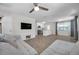 Open-concept living room with a modern aesthetic, featuring tile flooring, a ceiling fan, and a flat screen TV at 2873 Karen Ave, Largo, FL 33774