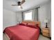 Inviting bedroom featuring a ceiling fan, tile floors, wooden nightstands, and a comfortable bed, perfect for relaxation at 2873 Karen Ave, Largo, FL 33774