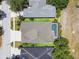 Aerial view of property with screen enclosed pool, surrounded by green grass and tropical trees at 2919 Northfield Dr, Tarpon Springs, FL 34688