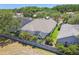Aerial view of property with pool, green grass, tropical trees, and privacy block wall at 2919 Northfield Dr, Tarpon Springs, FL 34688