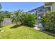 Landscaped backyard featuring lush lawn, stone wall, and screened-in pool area, perfect for outdoor relaxation at 2919 Northfield Dr, Tarpon Springs, FL 34688