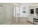 Bright bathroom with a glass shower, soaking tub, and single sink vanity at 2919 Northfield Dr, Tarpon Springs, FL 34688
