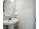Small bathroom with a white pedestal sink and a framed oval mirror at 2919 Northfield Dr, Tarpon Springs, FL 34688