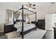 Elegant bedroom with a four-poster bed, dark wood furniture, and soft, neutral-toned curtains at 2919 Northfield Dr, Tarpon Springs, FL 34688
