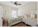 Cozy bedroom with hardwood floors, a ceiling fan, and a white dresser at 2919 Northfield Dr, Tarpon Springs, FL 34688