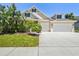 Charming home featuring a lush landscaped yard and a two-car garage at 2919 Northfield Dr, Tarpon Springs, FL 34688