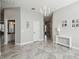 Bright foyer with chandelier lighting, neutral walls and decorative seahorse wall art at 2919 Northfield Dr, Tarpon Springs, FL 34688