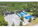Aerial view showcases the community's pickleball courts with shaded structures and pristine landscaping surrounded by trees at 2919 Northfield Dr, Tarpon Springs, FL 34688