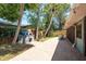 A backyard featuring a wood fired oven, brick paver path, mature trees, and landscaping at 3647 Scarlet Tanager Dr, Palm Harbor, FL 34683