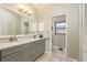 Bathroom features double sinks with gray cabinets, a large mirror, and access to a private toilet and shower area at 3647 Scarlet Tanager Dr, Palm Harbor, FL 34683