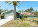 Charming single-story home with a well-maintained lawn, palm trees, and a red front door, providing great curb appeal at 3647 Scarlet Tanager Dr, Palm Harbor, FL 34683