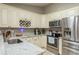 Well-lit kitchen with white cabinetry, stainless steel appliances, and granite countertops, offering a functional cooking space at 3647 Scarlet Tanager Dr, Palm Harbor, FL 34683