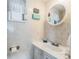 Bright bathroom featuring a white vanity, tiled walls, and a window with sheer curtains at 37229 Cora Ave, Zephyrhills, FL 33542