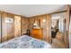 Inviting bedroom featuring wood-paneled walls, a plush bed, and an adjacent bathroom at 37229 Cora Ave, Zephyrhills, FL 33542