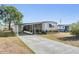 Single-story home featuring a covered parking area, screened-in porch, and neat landscaping at 37229 Cora Ave, Zephyrhills, FL 33542