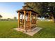 Charming wooden gazebo in a community, featuring built-in benches and set against a backdrop of open green space at 37229 Cora Ave, Zephyrhills, FL 33542