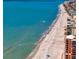 Stunning aerial view of a pristine beach with clear blue waters and beachfront properties along the coastline at 400 150Th Ave # 506, Madeira Beach, FL 33708
