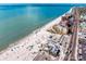 Wonderful aerial view of the beach with azure waters and beachfront properties, accompanied by lush palm trees at 400 150Th Ave # 506, Madeira Beach, FL 33708