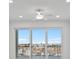 Bright bedroom with balcony access showcasing scenic neighborhood views at 400 150Th Ave # 506, Madeira Beach, FL 33708