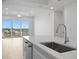 Modern kitchen with an island and stainless steel sink, connecting to the living room at 400 150Th Ave # 506, Madeira Beach, FL 33708