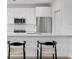 Modern kitchen features white cabinetry, stainless steel appliances, and bar seating at 400 150Th Ave # 506, Madeira Beach, FL 33708