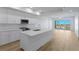 Modern kitchen showcasing an open layout to the living room with sleek appliances and island seating at 400 150Th Ave # 506, Madeira Beach, FL 33708