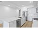 Open concept kitchen featuring an island with a sink, stainless appliances, and white cabinetry at 400 150Th Ave # 506, Madeira Beach, FL 33708