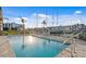 Community pool with tables, lounge chairs, and views of the harbor at 400 150Th Ave # 506, Madeira Beach, FL 33708