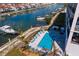 An aerial view of the Residences showcasing a pool with lounge spaces and access to boat slips at 400 150Th Ave # 506, Madeira Beach, FL 33708
