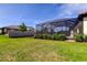Lush backyard featuring mature hedges and a large screened lanai provides a serene outdoor escape at 4975 Night Star Trl, Odessa, FL 33556