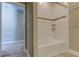 Bathroom with white tiled shower-tub combination and coordinated tile flooring, ideal for comfort at 4975 Night Star Trl, Odessa, FL 33556