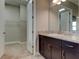 Bathroom vanity with dark wood cabinets, granite countertops, and open walk-in closet nearby at 4975 Night Star Trl, Odessa, FL 33556