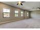 Large bedroom with multiple windows providing ample natural light and neutral colored walls and carpet at 4975 Night Star Trl, Odessa, FL 33556