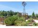 Charming community garden with wooden planters, a windmill, and a variety of herbs, vegetables, and flowers at 4975 Night Star Trl, Odessa, FL 33556