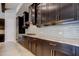 Modern kitchen with dark wood cabinets, stainless steel appliances, and white backsplash at 4975 Night Star Trl, Odessa, FL 33556